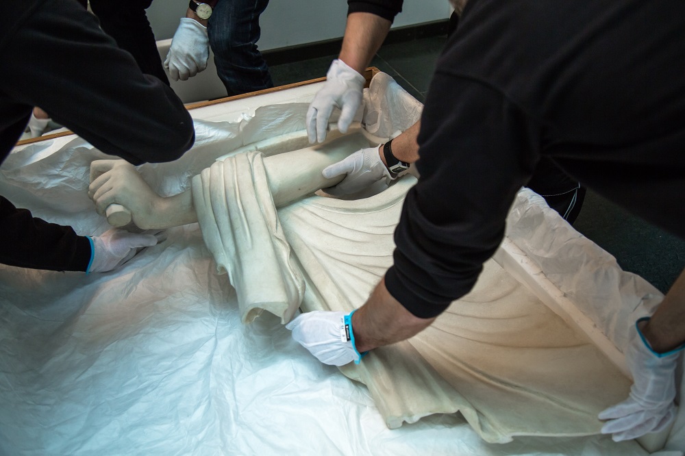 Hände verpacken einen Arm aus Gips