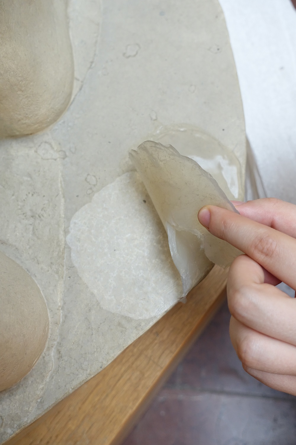 Eine Frauenhand zieht das getrocknete Gel ab